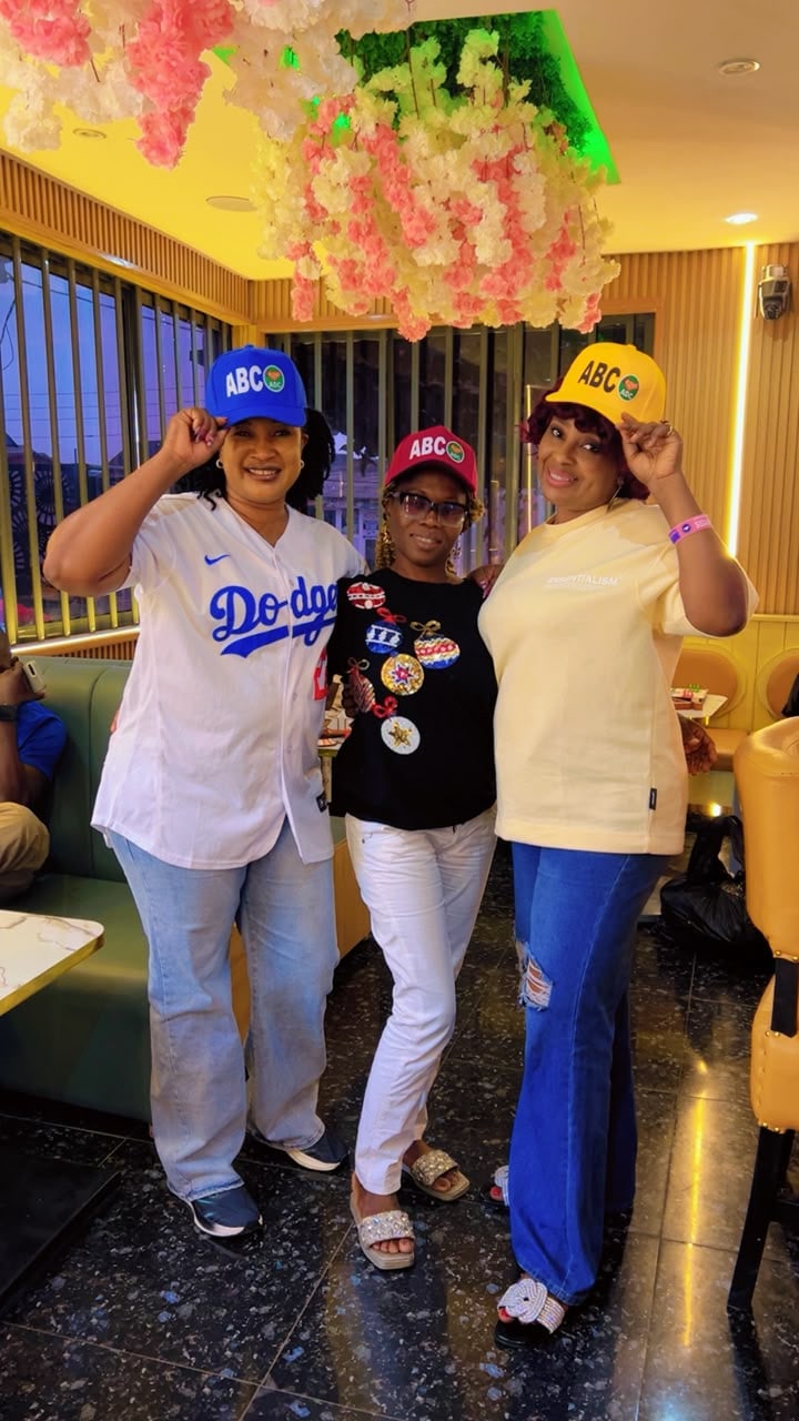Three Command Ojo classmates in matching caps at a restaurant